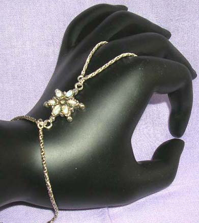 :925.sterling silver slave bracelet with white mother of seashell chips forming a flower design
