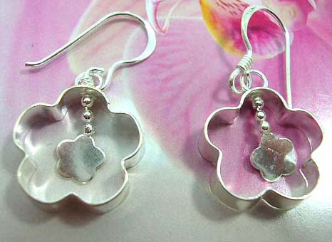 Sterling silver earring in carved-out flower frame with a mini flower pattern suspended in middle